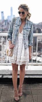 Jeune femme séduisante aux cheveux ondulés en veste et chemise en cuir noir regardant attentivement de côté sur fond beige. Blouson En Jean Oversize Stylee Fr