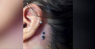 A tattoo behind the ear isn't seen. Small Black Semicolon Tattoo Behind The Ear For Women