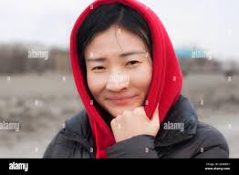 A smiling chinese woman wearing a red hoodie outside in a rural area of  zhaodong china in heilongjiang province Stock Photo