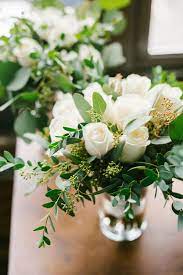 If you choose white flowers to decorate your wedding with, try filling your reception room with as many floral details to really show off the glamour and elegance of your big day! White And Green Wedding Flowers White Roses And Greenery Simple Wedding Flowers Wedding Flower Arrangements Green Wedding Flowers White Flower Arrangements
