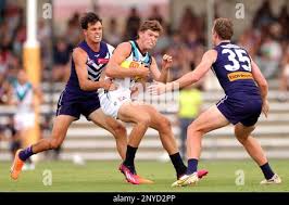 Mitch Georgiades of the Power is tackled by Heath Chapman and Josh Treacy  of the Dockers during the AFL official practice match between the Fremantle  Dockers and Port Adelaide Power at Fremantle