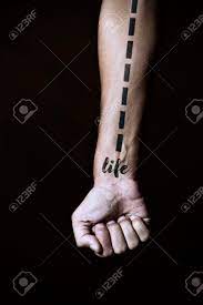 Gros Plan D Un Jeune Homme Caucasien Avec Une Ligne En Pointilles Et Le Mot Vie Simulant Un Tatouage Dans Son Avant Bras Sur Un Fond Noir Banque D Images Et Photos Libres De Droits