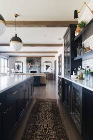 Farmhouse Black Cabinet Kitchen With Vintage Runner And Beams More Source On Home Bunch B Modern Farmhouse Kitchens Home Decor Kitchen Interior Design Kitchen