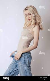 Beautiful blonde woman with long hair in jeans. Skinny girl with long legs,  weight loss, perfect figure Stock Photo - Alamy