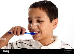 Young boy with brown hair brushing teeth