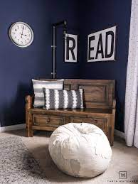 The youthful patterned wallpaper in this boy's room lends an energetic feel, while the soft muted blue creates a more calming environment. Navy Blue Boys Bedroom Taryn Whiteaker