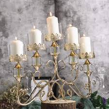 An autumn centerpiece showcases a gold hurricane holder. Gold 18 In Tall Candelabra Candle Holder Centerpiece With Glass