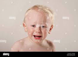 Blonde kurzhaarige traurig Kind weint mit Tränen in seinen blauen Augen  Stockfotografie