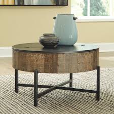 If you have a material of choice, look through a wide range of tables in different materials like marble, glass, wood, and metal. The Nashbryn Gray Brown Round Cocktail Table On Sale At Montana S Home Furniture Serving Houston Tx