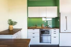 Cuisine D Un Studio Gain De Place Plan De Travail Noyer Mur Vert Credence Verre Combine Fou Combine Four Lave Vaisselle Four Lave Vaisselle Amenagement Cuisine