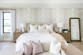 Natural bedroom with wooden furniture, pink and beige blankets, paper clock and pouf. Beige And Pink Bedroom Colors Transitional Bedroom