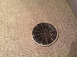 You have to clean up those ugly stains or they'll only worsen post painting. Close Up Of Floor Drain Cover Over Carpet Basement Flooring Basement Floor Drain Floor Drain