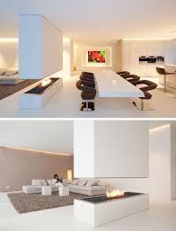Enjoy beauty and warmth from multiple angles with the three sided fireplace. A Minimalist Room Divider Incorporates A Tv And Open Fireplace In This Home