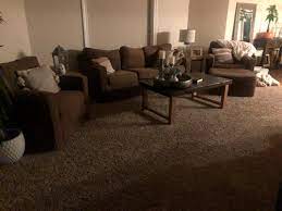 The walls are a yellow color. Dark Brown Carpet And Sofa