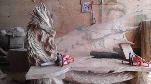 Un Escultor Estonio Talla Con Una Motosierra Un Dragon En Un Banco Cultura Inquieta Mythical Dragons Beautiful Dragon Chainsaw Carving