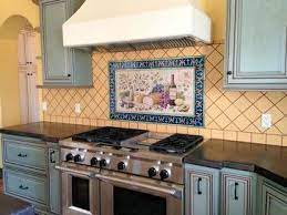 Just a like a beautifully painted feature wall in any other room of a home, the area above the cooktop in a kitchen provides a great space for a pretty interior design moment in a kitchen. Patterned Tile Frame Around Tile Mural Behind Stove With Diamond Backsplash Diy Kitchen Backsplash Country Kitchen Backsplash Hand Painted Tiles Kitchen
