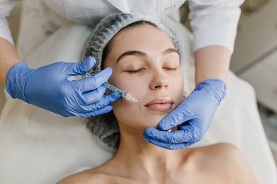 Aesthetic practitioner holding skincare products