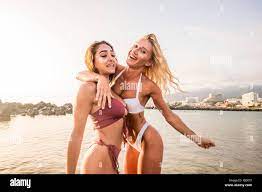 couple of thin sexy babes young woman blonde and brunette enjoy the summer  vacation hugging and laughing together. playful activity for beautiful fem  Stock Photo - Alamy