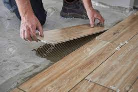 Search for tile for flooring with us Hands Of The Tiler Are Laying The Ceramic Wood Effect Tiles On The Floor Stock Photo Picture And Royalty Free Image Image 120552118