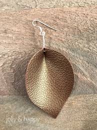To make glitter faux leather earrings, you need some heat transfer glitter vinyl to add to the faux leather. Joanna Gaines Inspired Faux Leather Leaf Earrings Jolly Happy Diy Leather Earrings Leather Jewelry Faux Leather Earrings
