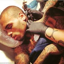 Chris brown body art includes the words symphonic love and a pair of wings across his chest, a smiley face with a skull peeking out on the back of his neck, and a day of the dead image that some initially thought looked like his. Chris Brown Gets More Tattoos On His Neck As He Snoozes While Getting Needled Daily Mail Online