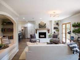 The room has a burlap covered ottoman, a white metal tray, white metal pitchers, a distressed bird cage, empty vintage frames, and a distressed white wood shutter for decorations. Pin On Living Room Ideas