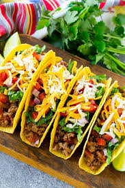 Crispy Ground Beef Tacos With An Assortment Of Toppings Like Lettuce Tomato And Shredded Cheese Ground Beef Tacos Taco Dinner Taco Recipes Ground Beef