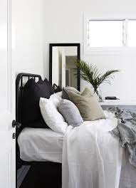 Black Iron Bed Frame With All White Linens Black And White Striped And Army Green Throw Pillows Fort Fie Coastal Bedrooms Black Bed Frame Coastal Bedroom