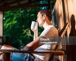 Image of relaxed person sipping coffee on a porch