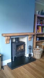 The shelf has visible distressing and slight imperfections that add visual intrigue. Waney Edge Rustic Curved Corbel Oak Beam Mantel Shelf Oak Fire Surrounds Log Burner Living Room Oak Fire Surround Fireplace