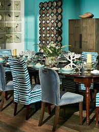 In This Warm Blue Dining Room By Oka A Dark Wooden Dining Table Creates The Perfect Backdrop For Gl Dining Room Blue Turquoise Dining Room Velvet Dining Chairs