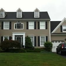 Plantation shutters are priced up by their square footage so the bigger they are the more expensive they will be. Black Shutters And Black Detailing In White Windows White Exterior Houses Tan House Exterior House Colors