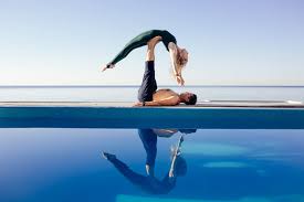 The more yoga you do, the more you realize that there's really no such thing as advanced yoga. Acro Yoga Concept Pair Yoga Couple Of Young Sporty People Practicing Yoga Lesson With Partner Man And Woman In Yogi Exercise Arm Balance Pose Working Out By Pool Above Beach Against Blue