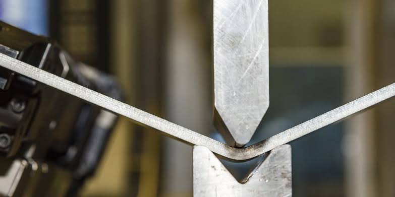 Trabajo de doblez de piezas metálicas en entorno industrial