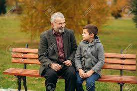 El Abuelo Y Su Nieto Pasan Tiempo Juntos En El Parque Estan Sentados En El Banco Paseando Por El Parque Y Regocijandome Fotos Retratos Imagenes Y Fotografia De Archivo Libres De Derecho