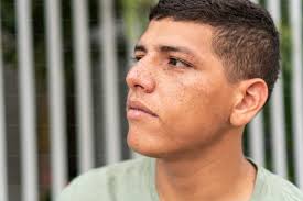 Foto Seorang anak laki-laki duduk di tanah membaca buku