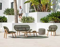 A dining table poolside is ideal for a relaxing eating experience, especially with tiki torches providing an ambient glow. Abigail Rope Outdoor Sofa