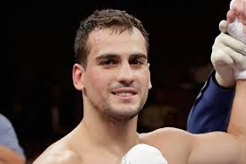 Who is Phil Lo Greco, what is Amir Khan's opponent's boxing record and has  he won any titles in his career?