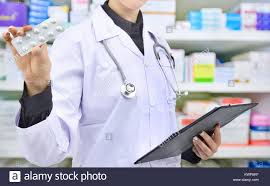 Pharmacist Holding Medicine Capsule And Prescription Chart