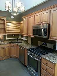 Light Colored Cabinetry With Stainless Steel Appliances And Bronze Hardware Bronze Faucet And Bronze Chandel Kitchen Decor Honey Oak Cabinets Home Appliances