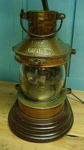 This rustic lamp features a rusty resin lantern base with an amber glass globe, a burlap shade with black accents, and a coordinating rusty finial. Reserved For Bill Miller Ship Lamp Lantern Vintage Tung Woo Masthead Ship S Lantern Table Lamp Copper And Brass Lantern Table Lamp Oil Lamps Old Lanterns