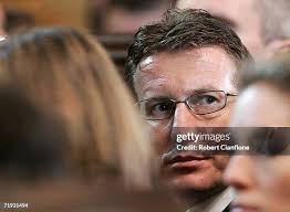 Elliott Summers, son-in-law of the late Peter Brock holds his son... News  Photo