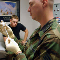 US Air Force (USAF) STAFF Sergeant (SSGT) Enoch Daniels, with the 6th  Medical Group (MG), gives a flu vaccination using a biojector to STAFF  Sergeant (SSGT) Monica Figueroa, from the 6th Comptroller
