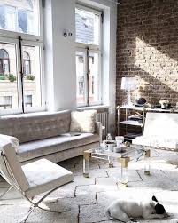 Modern living room design with marble fireplace, barcelona cocktail table, modern linen chair, taupe velvet sofa, hairhide black ottomans, modern console table, mirror, art and taupe walls. Barcelona Chair Midcentury Living Room New York By Barcelona Designs