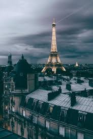 The city sparkled, lights reflecting off the seine as the streetlamps shone across the city. C D K Parisian Rooftops Photography By C D K