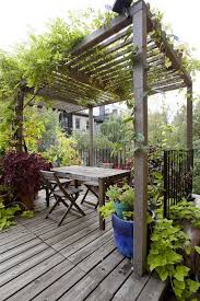 Holzterrasse Holz Pergola Kletterpflanzen Rustikaler Tisch A Hummel Holz Holzterrasse Hummel Pergolakletterpflanze Rustic Patio Outdoor Pergola Pergola