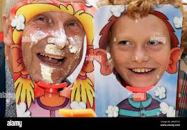 Alan Twigg, left, and Archie Twigg, 11, right, play with the Pieface  Showdown game, during a media opportunity at Hamleys toy shop in London,  Thursday, Oct. 6, 2016. The game retails at