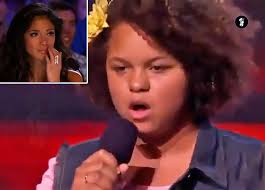 The Music Man - A young girl with a frizzy bob walks onstage and when Simon  asked what song she will be singing, she replied, "it's a surprise". 13-year -old Rachel Crow is