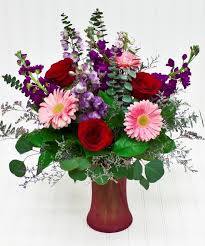 This Bouquet Embodies The Essence Of Love Through Red Pink And Purple Blooms Roses Gerbera Daisies And Delphin Flower Delivery Blossom Flower Purple Roses