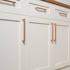 Amazing kitchen features white raised panel cabinet s adorned with copper hardware paired with white marble countertops and a white subway tiled backsplash. Edgecliff Pull Satin Copper Copper Handles Kitchen Kitchen Cabinet Remodel Copper Hardware Kitchen